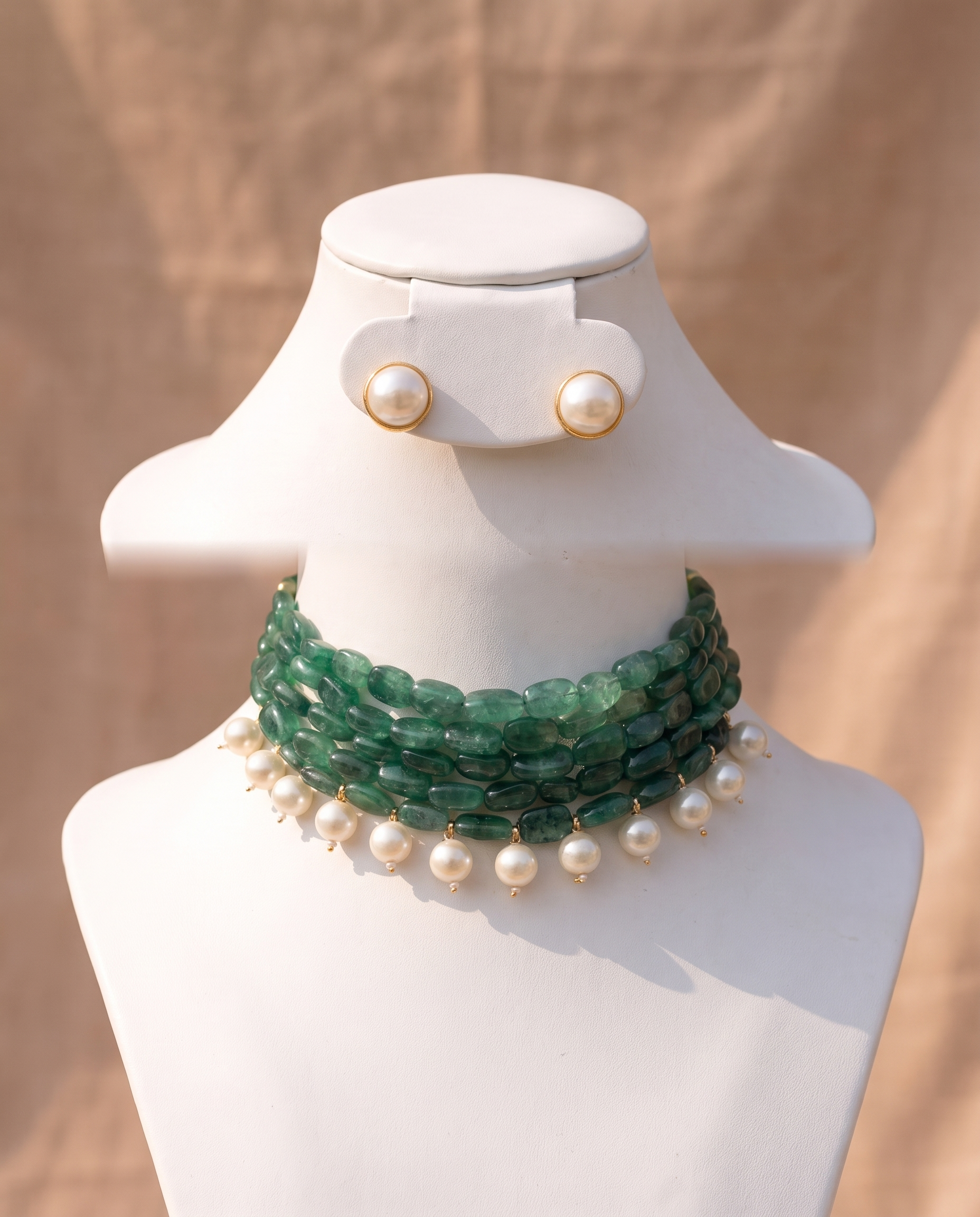 Four strands of green stone with white pearl drops, plus matching studs. A choker that finishes a plain neckline. Anti-tarnish, gold-toned finish.